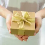 Steuerberatung Reindl, Hergenröder und Partner - Eine Frau hält ein Geschenk in der Hand. Beachten Sie bei größeren Geschenken die Schenkungssteuer.