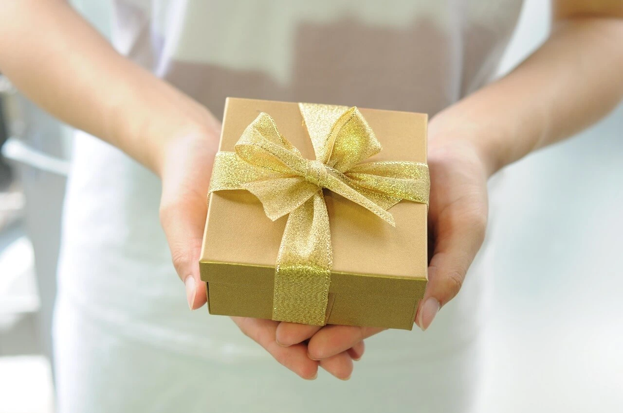 Steuerberatung Reindl, Hergenröder und Partner - Eine Frau hält ein Geschenk in der Hand. Beachten Sie bei größeren Geschenken die Schenkungssteuer.