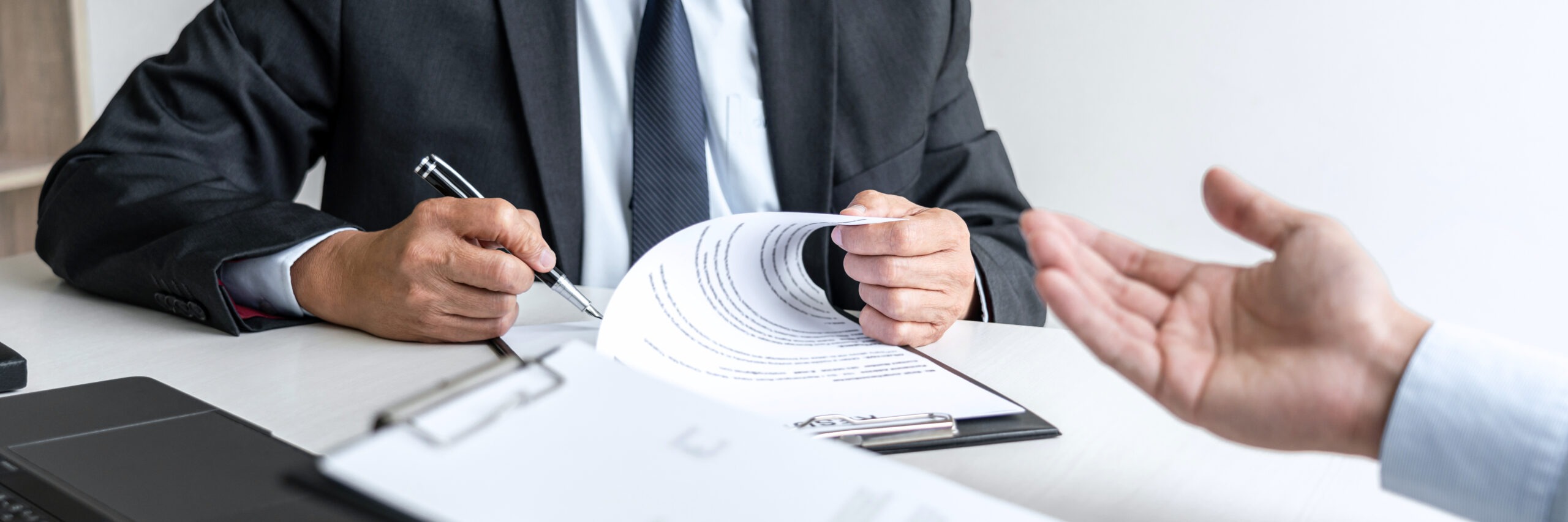 Steuerberatung Reindl, Hergenröder und Partner - Mann hält Stift in der Hand und unterschreibt Papier.