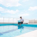 Steuerberatung Reindl, Hergenröder und Partner - Mann sitzt mit Laptop am Pool