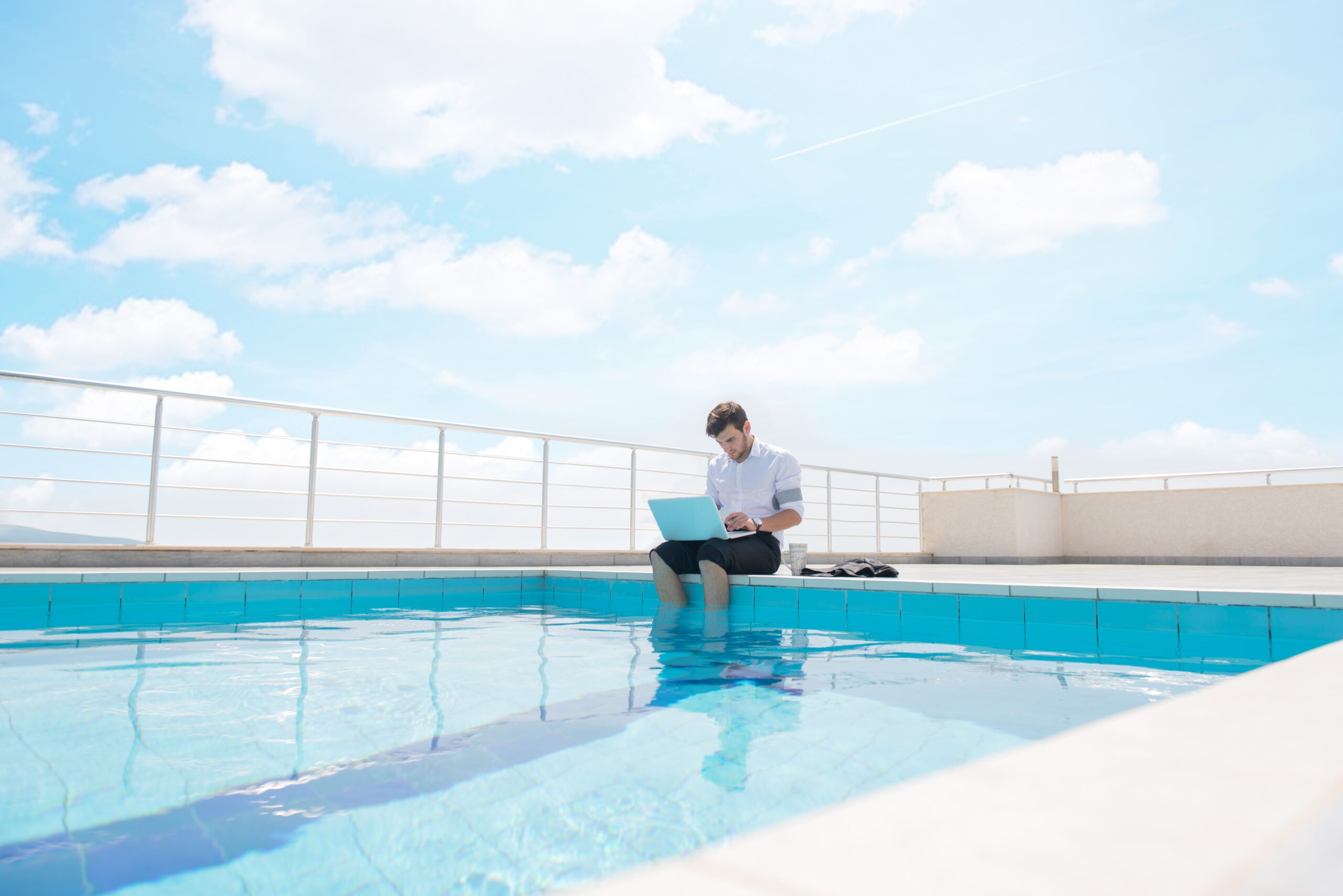 Steuerberatung Reindl, Hergenröder und Partner - Mann sitzt mit Laptop am Pool