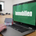 Steuerberatung Reindl, Hergenröder und Partner - Laptop mit einem grünen Bildschirm, auf dem Immobilien steht.