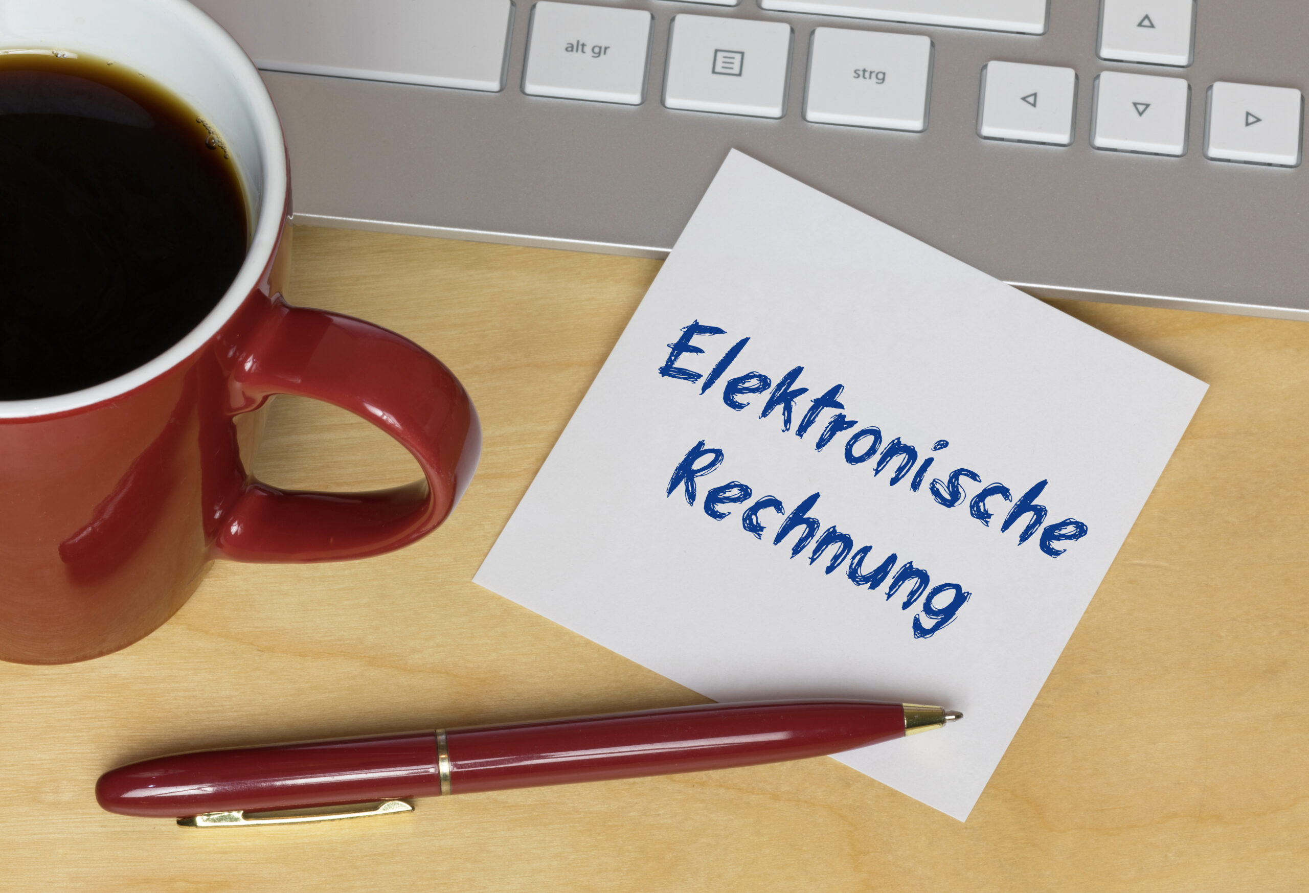 Steuerberatung Reindl, Hergenröder und Partner - Zettel mit dem Schriftzug Elektronische Rechnung neben einem Kugelschreiber und einer Tasse
